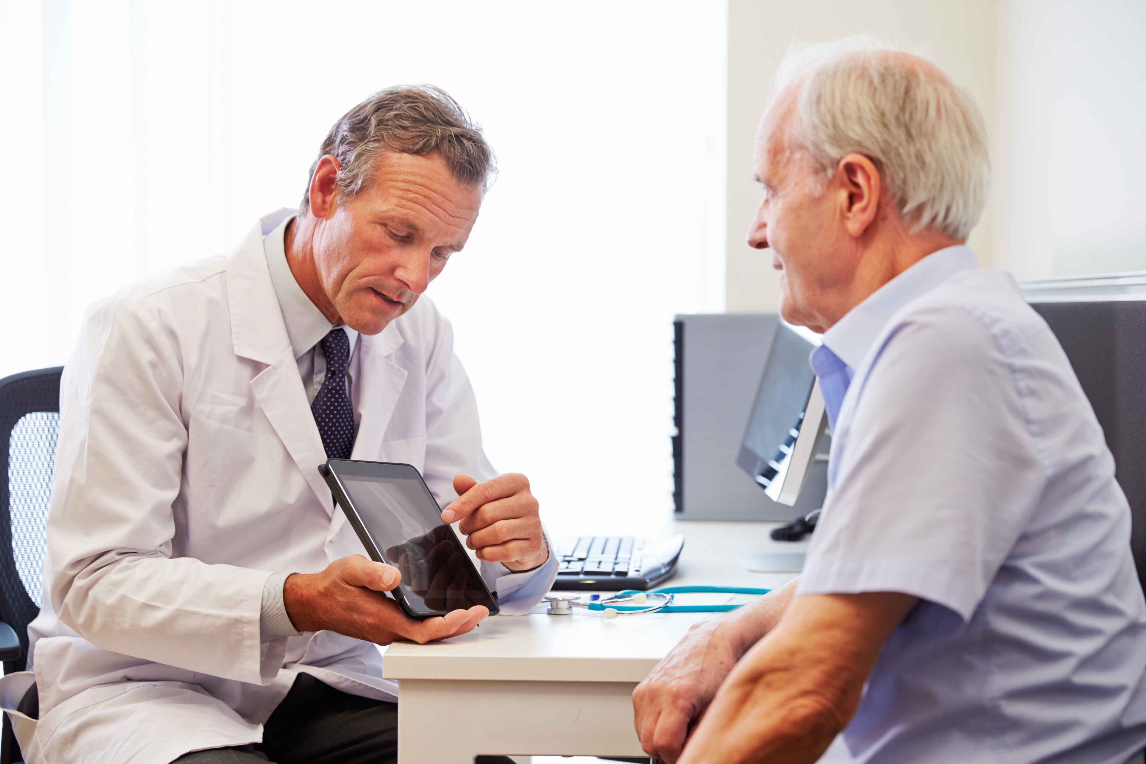 Senior Patient Having Consultation With Doctor In Office
