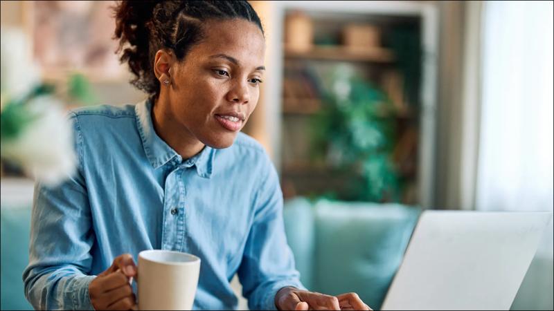 A professional woman working on a laptop in a modern office