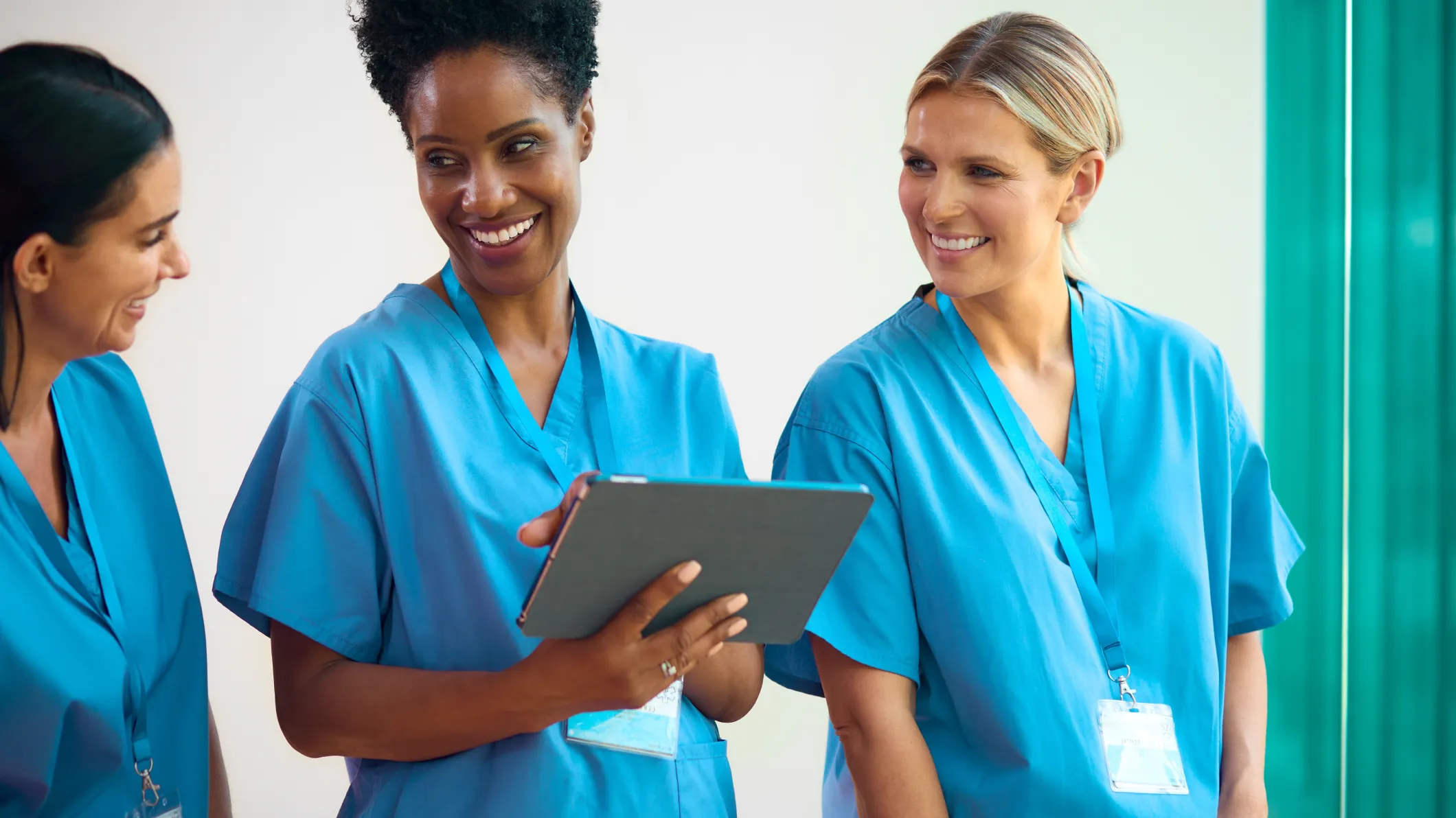 A team of female doctors smiling together on a ward