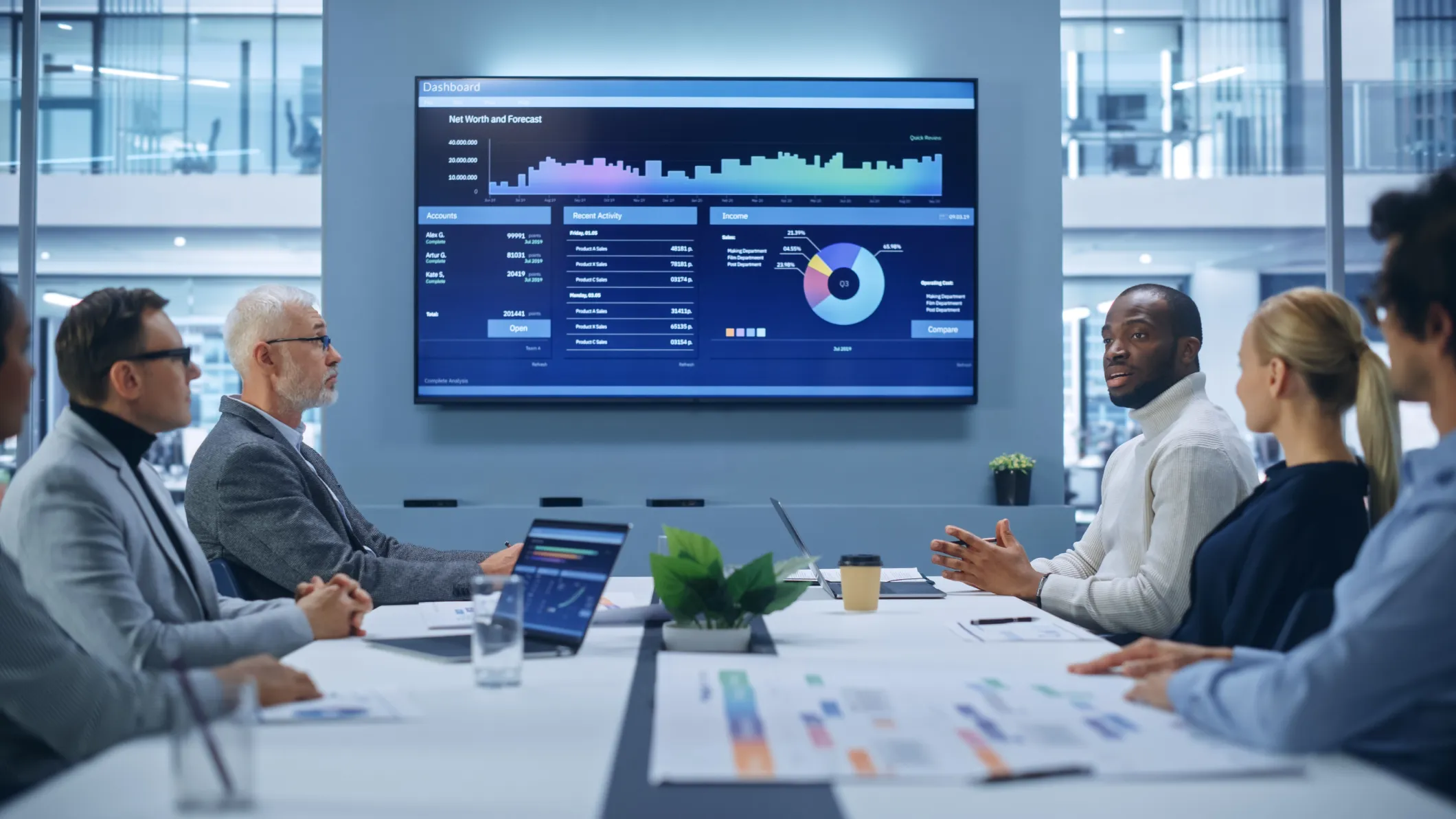 Finance professionals collaborating in a conference room while reviewing and analysing data