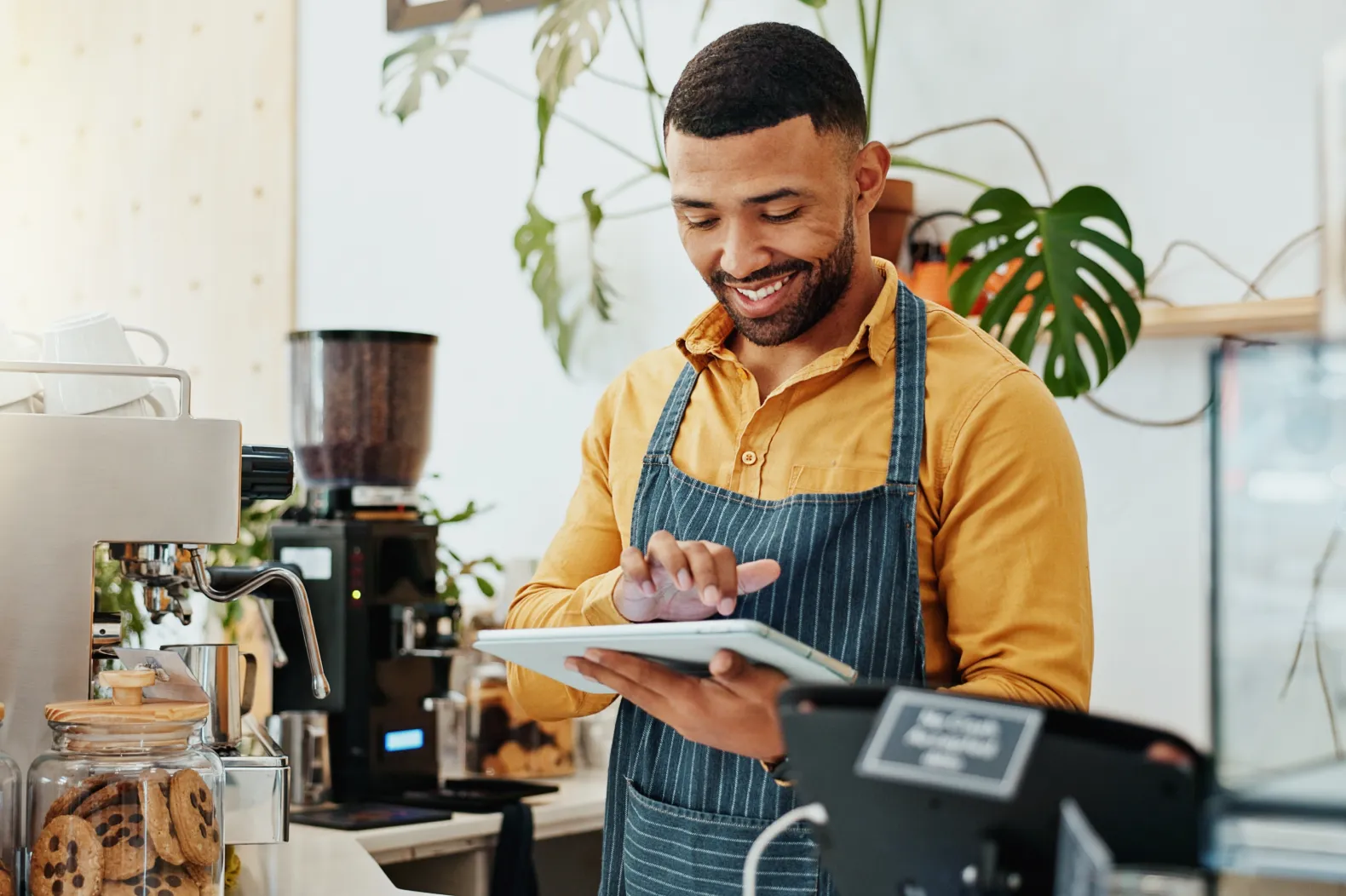 Coffee shop worker making use of retail ERP software