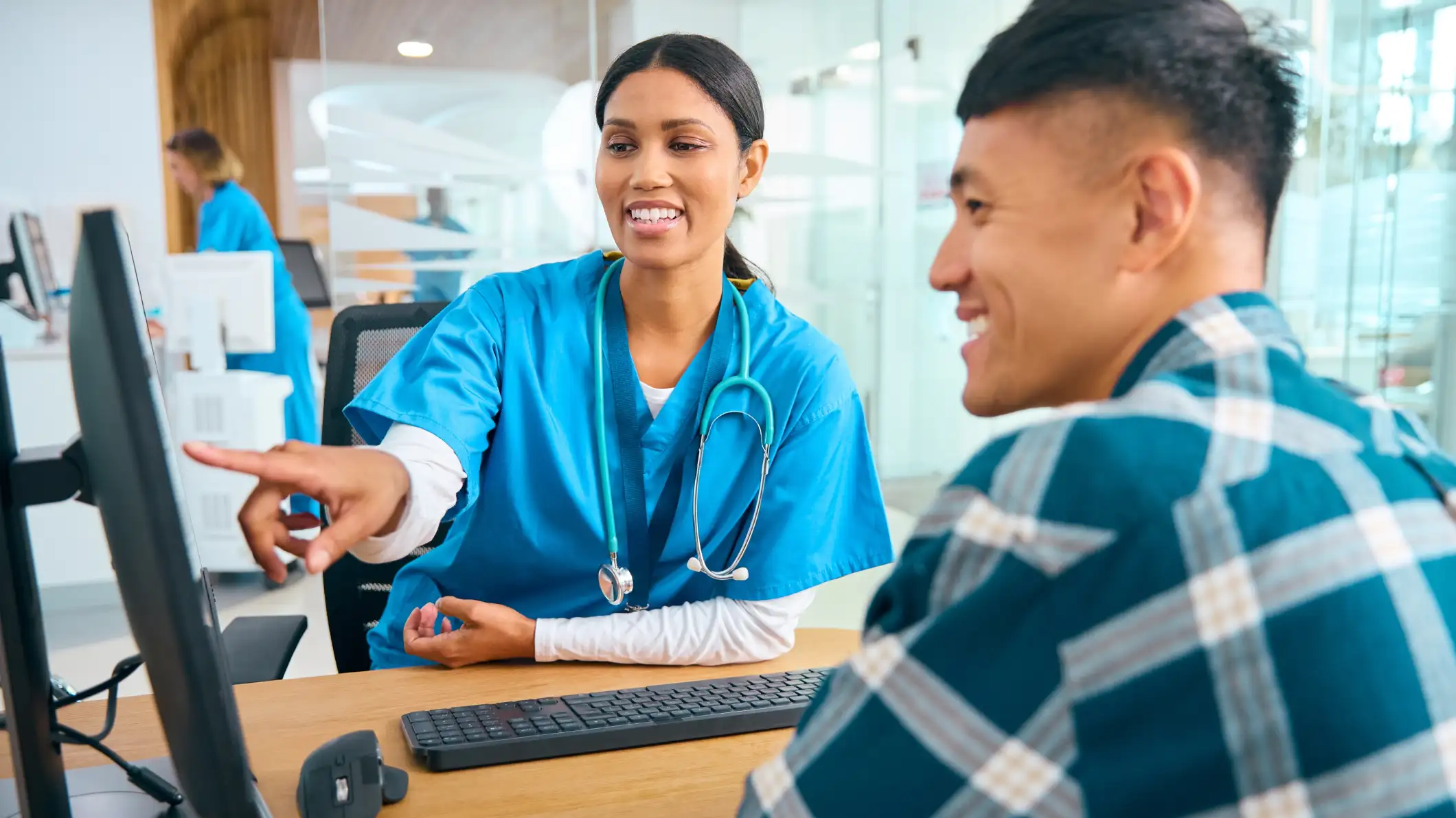 A female doctor in an appointment with a male patient looking at a computer screen