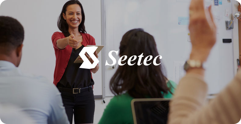 Teacher pointing to student with their hand up with Seetec logo overlay